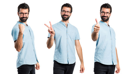 Handsome man with blue glasses making victory gesture