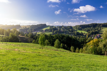 Fototapeta na wymiar Saxon Switzerland (Bohemian Switzerland or Ceske Svycarsko) meadow and village on a sunny day in summer