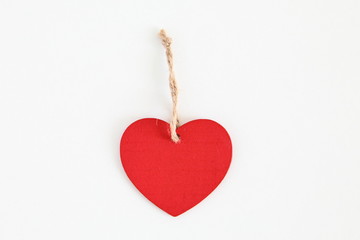 Red wooden heart shaped tag with rope isolated on white