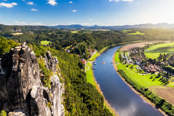 View from viewpoint of Bastei in Saxon Switzerland Germany to the town city and the river Elbe on a sunny day - obrazy, fototapety, plakaty
