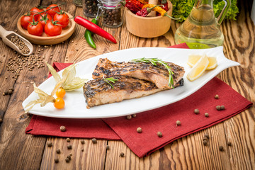 Fried fish carp on the grill on a wooden table