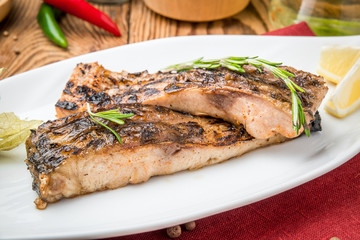 Fried fish carp on the grill on a wooden table
