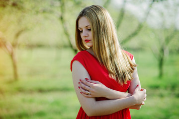 Obraz premium Portrait of light hair girl on red dress background spring garde
