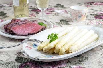 Roast Beef with White Asparagus as close-up on a Plate