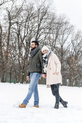 Fototapeta na wymiar Loving couple enjoying the snow in the park