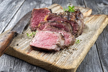Barbecue Point Steak as close-up on old Cutting Borad
