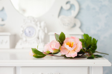 Artificial rose flower on a white wooden table