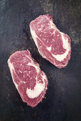 Dry Aged Entrecote Steak as top view on old Metall Sheet