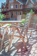 Fototapeta na wymiar Chairs and glass table on brick terrace at countryside 