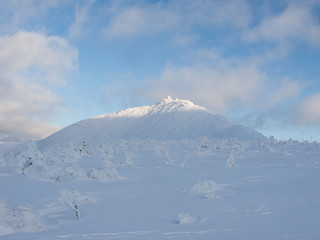 Widok na Śnieżkę zimą w popołudniowym słońcu.
