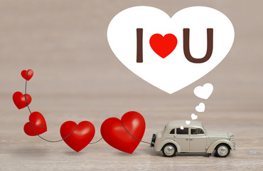 Vintage miniature Car with heart shaped balloon and I love You text.  concept of love. wedding, honeymoon or valentine's day background 