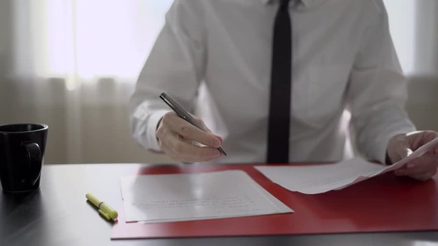 Man drinks coffee while doing paperwork