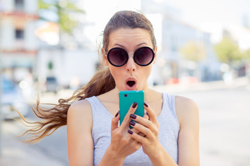 shocked anxious scared young girl looking at phone seeing bad news