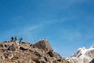 Fototapeta premium Mountain Peak with buddhist prayer Flags and Climbers walking