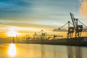Obraz premium sunrise view to Bilbao industrial cranes, spain