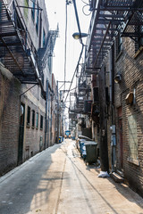 Fototapeta premium Narrow lane between buildings with fire ladders.