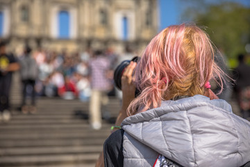 Close up of photographer with professional camera from back, on stairs of Ruins of St. Paul's, one of most popular attractions in Macau, China. Blurred background of iconic facade.Travel asian concept