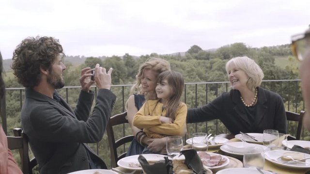 Father taking picture of family meal