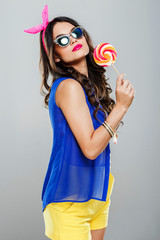 Girl in blue and yellow holding lollipop