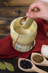 man prevents the spices in a mortar