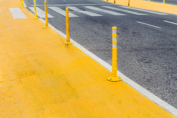Yellow zone in the asphalt of a street delimited by flexible pil