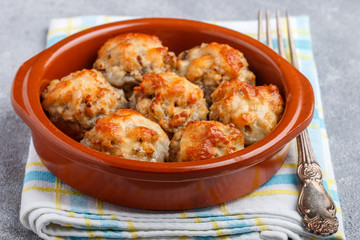 Stuffed mushrooms, baked with cheese in a ceramic form
