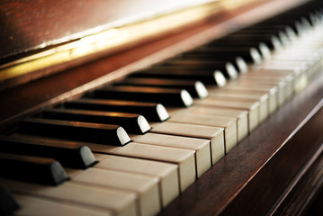 Piano keyboard of an old music instrument, close up with blurry background