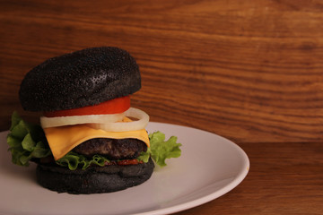 Homemade black burger on a wooden table. rural food 