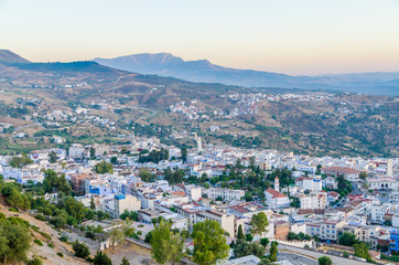 Fototapeta na wymiar Beautiful historical town Chefchaouen with its blue washed buildings viewed from a hill during sunset, Morocco