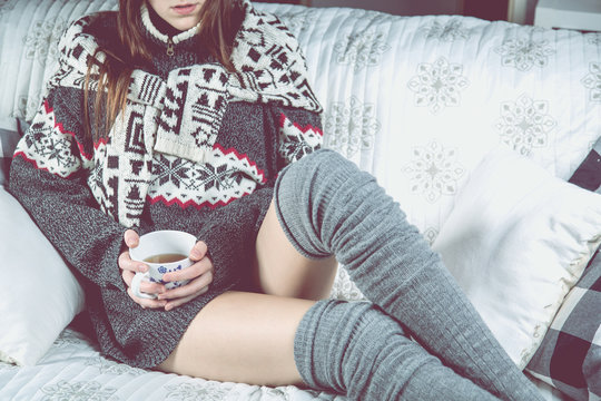 Girl is relaxing on the sofa with tea, winter cozy concept