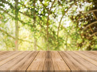 Poster de jardin Nature Table vide de planche de bois devant un arrière-plan flou. Table en bois brun en perspective sur des arbres flous sur fond de forêt - peut être utilisée comme maquette pour l& 39 affichage ou le montage de vos produits. saison de printemps.
