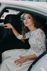 close-up portrait of a pretty shy bride in a car window