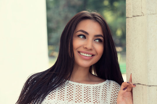 Closeup portrait of confident smiling happy pretty young woman in white shirt