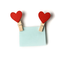clothespins with red hearts holding a blue sticker