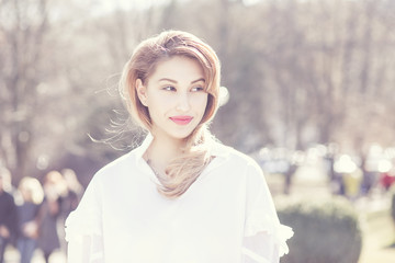 Portrait of woman smiling with perfect smile in a park outdoors background late autumn winter