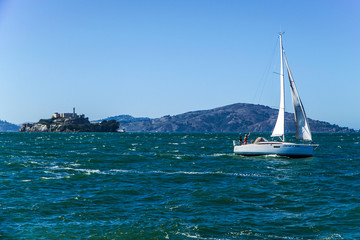 A sailboat on the the San Francisco Bay on a windy summer day with Alcatraz Island in the Background
