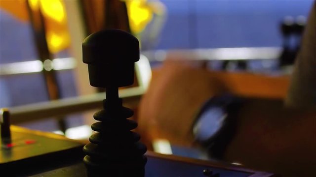 Tug master controls bow thruster. Close-up of hands in a low light