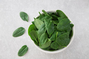 Washed fresh mini spinach in a plate on an stone background