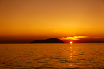 Rejs o zachodzie słońca po Morzu Egejskim z widokiem na wyspy na horyzoncie - obrazy, fototapety, plakaty