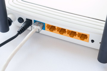 router and the connected internet cable close up on white background