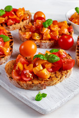 Tasty Traditional Tomato bruschetta with fresh basil on white board