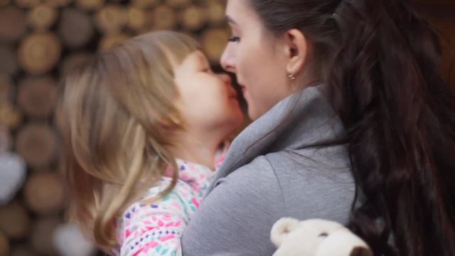 Closeup of a loving mother tenderly kissing little daughter