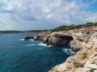 Mallorca cliff with cave and cloudy sky