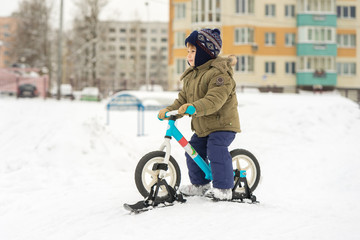 Boy on bike with skis preparing to move down from the mountains