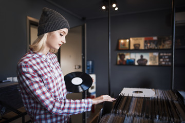 beautiful young woman browsing records in the vinyl record store