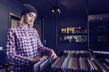 beautiful young woman browsing records in the vinyl record store
