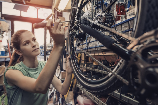 woman bicycle engineer is repairing a bike in the workshop