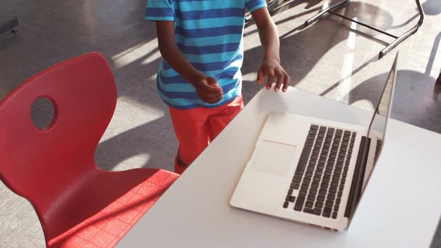 Schoolboy using laptop in classroom