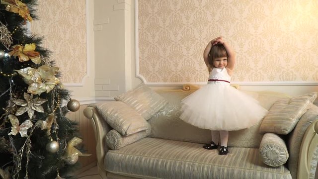 Little beautiful ballerina on the big couch