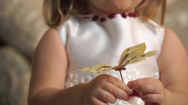 Closeup of a golden butterfly in children's hands